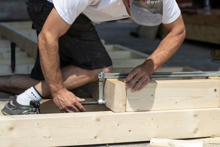 Zimmerer mit Holzbalken